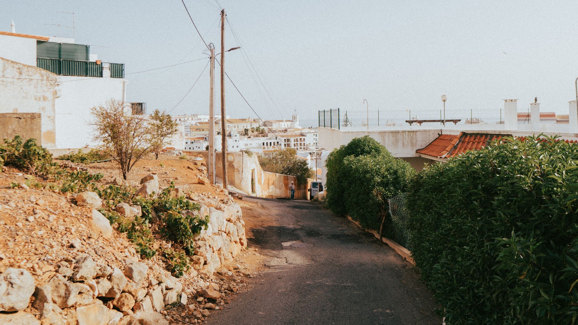 A sunny narrow street in Albufeira, Portugal, with the sea at the end of it.